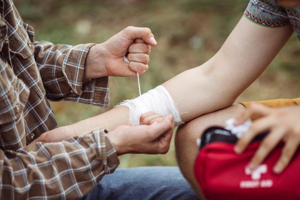 A person wrapping his friends arm in gauze SafetySkills