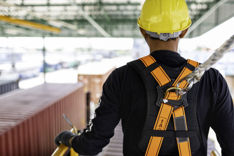 Construction worker wearing safety harness and safety line worki