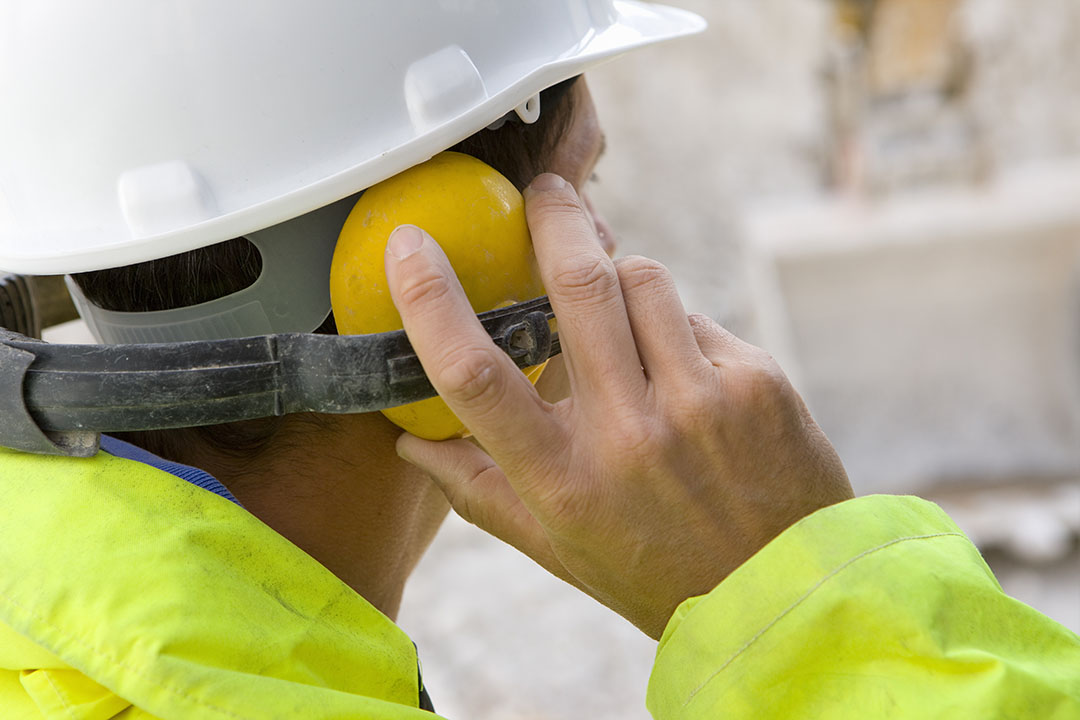 Construction worker wearing protective hard hat and ear defender