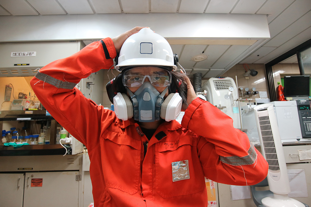 Employee in orange jumpsuit and respirator SafetySkills