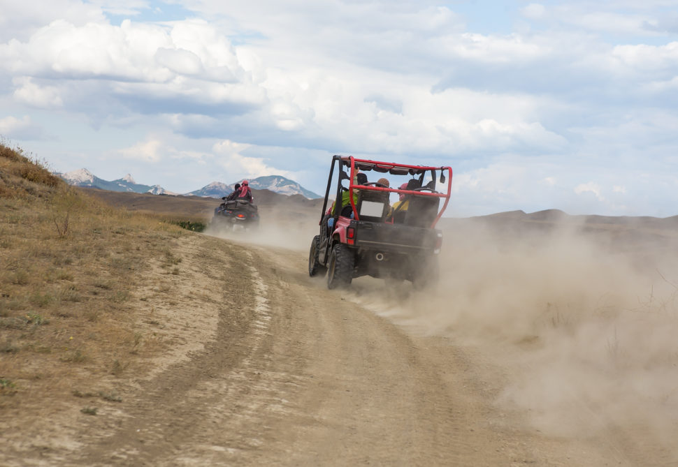 Two UTV's on a dirt road.