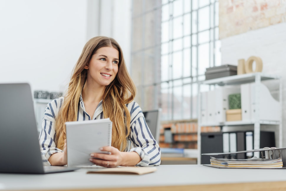 Young woman smiles at desk