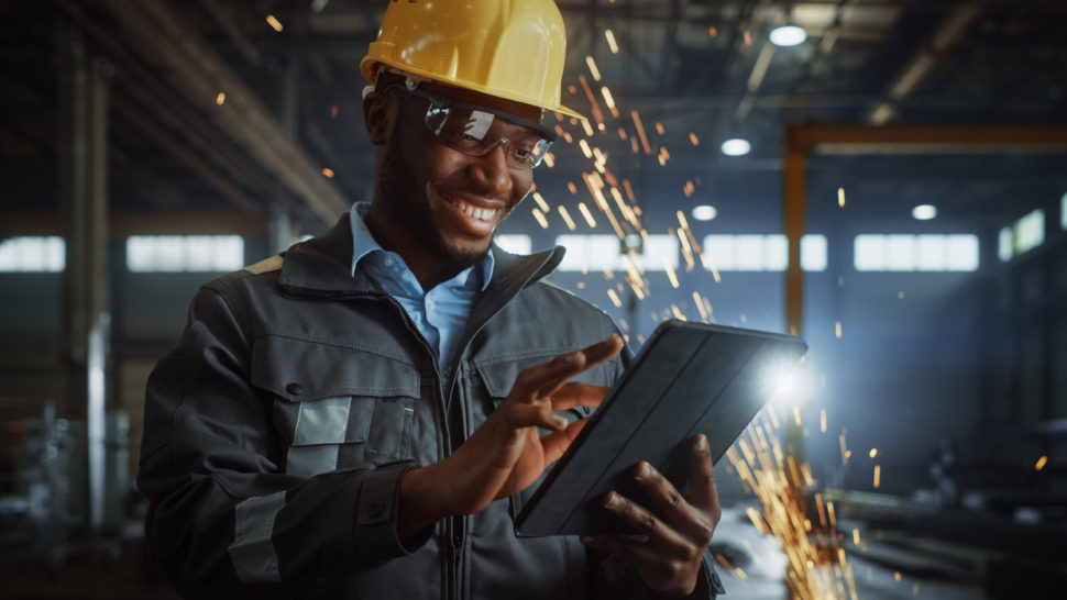 man in factory holds ipad