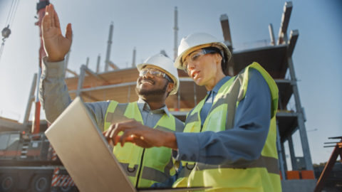 Two workers discussing over an iPad on jobsite