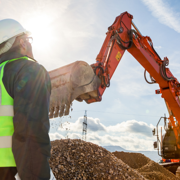 Construction worker inspecting machinery operation